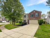 Charming two-story home featuring a brick facade, attached garage, and a well-maintained front yard at 2116 Orchid Bloom Dr, Indianapolis, IN 46231