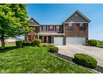 Beautiful two-story home with brick and siding, red shutters, a well-manicured lawn and a two car garage at 2209 S Logan Dr, New Palestine, IN 46163