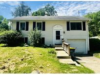 Charming home with black shutters, lush landscaping, and an attached garage at 2419 Tamarack Pl, Anderson, IN 46011