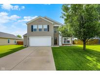 Charming two-story home featuring a manicured lawn and a two-car garage at 5517 Jona Way, Bargersville, IN 46106
