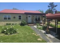 Charming single-story home with a red roof, stone facade, covered porch and beautifully landscaped front yard at 705 S 450 E, Franklin, IN 46131