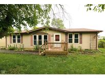 Charming single-story home featuring a front porch and well-maintained lawn and beige vinyl siding at 7214 W Reformatory Rd, Fortville, IN 46040