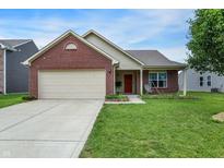 Charming single-story home featuring a brick facade, attached garage, and well-maintained lawn at 7238 Moultrie Dr, Indianapolis, IN 46217