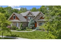 Beautiful brick home featuring a well-manicured lawn and lush landscaping at 7744 Preservation Dr, Indianapolis, IN 46278