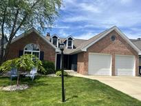 Charming brick home featuring an attached two-car garage and well-manicured front lawn at 7838 Chesapeake E Dr, Indianapolis, IN 46236
