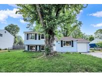 Charming two-story home featuring light blue siding, black shutters, and a well-manicured lawn at 7915 Broadview Dr, Indianapolis, IN 46227