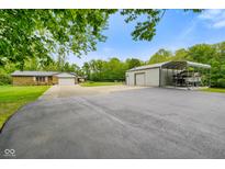 Exterior of property with long driveway, storage shed, car port, and two-car attached garage at 8000 Mcwhorter Rd, Martinsville, IN 46151