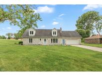Charming stone home with a well-manicured lawn, attached garage, and lovely curb appeal at 8465 Hilltop Ln, Martinsville, IN 46151
