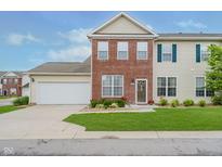 Charming two-story home featuring a brick facade, attached garage, and well-manicured front lawn at 9689 Wild Iris Dr, Noblesville, IN 46060