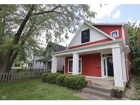 Charming red two-story home featuring a covered front porch with white columns and manicured landscaping at 1156 Spruce St, Indianapolis, IN 46203