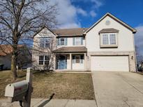 Charming two-story home featuring vinyl siding, blue shutters, a driveway, and an attached two-car garage at 11754 Hamble Dr, Indianapolis, IN 46235