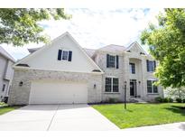 Charming two-story home featuring a brick facade, attached garage, and a well-manicured lawn, offering classic curb appeal at 12093 Ashland Dr, Fishers, IN 46037