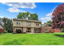 Charming two-story home with a well-manicured lawn, mature trees, and an American flag displayed at 1219 Driftwood Dr, Carmel, IN 46033