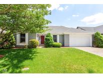 Charming single-story home featuring a lush green lawn, brick facade, and attached garage at 12289 Charing Cross Rd, Carmel, IN 46033