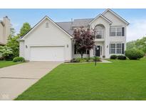 Charming two-story home features an attached two-car garage and a well-manicured lawn at 13896 Fernleaf Way, Carmel, IN 46033