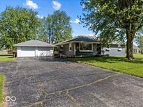 Charming single-story home with a detached two-car garage, a large driveway, and a well-maintained lawn at 2233 S Miller Ave, Shelbyville, IN 46176