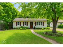 Charming single-story home with a well-manicured lawn, mature trees, and a welcoming walkway at 332 Campus Ln, Indianapolis, IN 46219