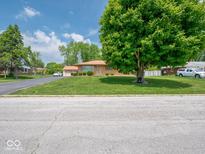 Charming brick home with a well-manicured lawn and mature tree, offering great curb appeal at 3538 Whalen Ave, Indianapolis, IN 46227