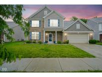 Inviting two-story home featuring brick facade, attached two-car garage, and a well-maintained front yard at 5374 John Quincy Adams Ct, Plainfield, IN 46168