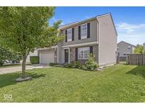 Charming two-story home featuring a well-maintained lawn and a mature tree, perfect for Gathering living at 5671 Glass Chimney Ln, Indianapolis, IN 46235