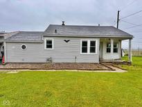 Quaint single-story home with a well-maintained lawn and neutral-colored siding under an overcast sky at 613 Anderson Rd, Anderson, IN 46017