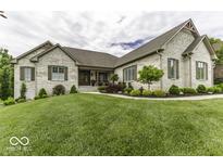 Charming brick home with manicured lawn and landscaping, complemented by stylish shutters at 7648 Killarney Dr, Indianapolis, IN 46217
