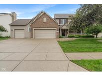Charming two-story home featuring a brick facade, three-car garage, and manicured lawn at 7978 Park Meadows Dr, Brownsburg, IN 46112