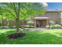 Charming brick home featuring a well-manicured lawn and a mature tree in the front yard at 876 Box Turtle Ct, Columbus, IN 47201