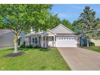 Charming single-story home with brick accents, attached garage, and well-maintained lawn and mature trees at 9229 Crossing Dr, Fishers, IN 46037