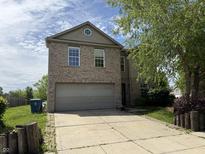 Two-story home featuring a two-car garage and well-maintained lawn with a long driveway at 10803 Gathering Dr, Indianapolis, IN 46259