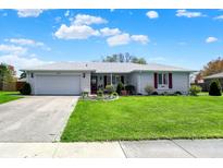 Charming single-story home with white brick, red shutters, and a well-manicured lawn at 1111 Cambridge Dr, Greenwood, IN 46142