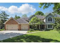 Charming two-story home with a well-manicured lawn, brick accents, and an attached two-car garage at 12335 Old Stone Dr, Indianapolis, IN 46236