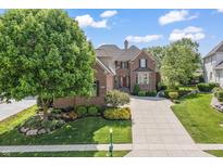 Beautiful brick home boasts mature landscaping and a spacious driveway at 16502 Grand Cypress Dr, Noblesville, IN 46060