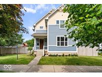 Charming two-story home featuring blue siding, complemented by a well-manicured lawn and inviting curb appeal at 2448 Broadway St, Indianapolis, IN 46205