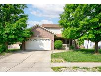 Charming home featuring a brick facade, two-car garage, and well-maintained lawn with mature trees at 286 N Greenbriar Dr, Greenwood, IN 46142