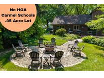 Backyard features a cozy fire pit area with seating, perfect for outdoor relaxation and entertainment at 3479 Sugar Loaf Ct, Carmel, IN 46033
