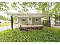 Charming home featuring a cozy covered front porch with fresh landscaping at 4910 W Caven St, Indianapolis, IN 46241