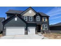 Two-story home features a two-car garage, gray siding, brick accents, and a charming, covered porch at 6418 Springtide Ct, Plainfield, IN 46168