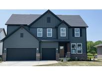 Stunning two-story home featuring a three car garage, covered porch and a dark grey exterior at 6418 Springtide Ct, Plainfield, IN 46168