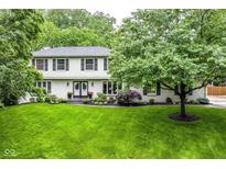 Charming two-story home featuring a manicured lawn and lush landscaping at 6530 Lowanna Way, Indianapolis, IN 46220