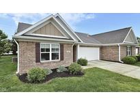 Charming brick home featuring a two-car garage, manicured lawn, and decorative window shutters at 695 Overcup St, Westfield, IN 46074