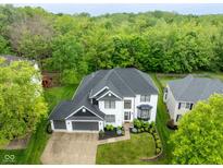 Stunning aerial view of a white house with a dark gray roof and lush green surroundings at 7022 Tamarind Ct, Indianapolis, IN 46236