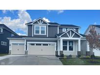 Beautiful two-story home with a three car garage and a manicured lawn at 7145 Firestone Rd, Whitestown, IN 46075