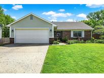 Charming single-story home with a two-car garage and well-manicured lawn and flower beds at 7437 Lorene Ct, Indianapolis, IN 46237