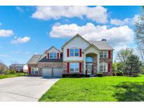 Beautiful two-story home featuring a brick facade, red shutters, and a well-manicured front lawn at 7637 Sand Run Ct, Indianapolis, IN 46259