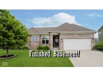 Charming single-story brick home with a manicured lawn and an attached two car garage at 7724 Dunleer Dr, Brownsburg, IN 46112