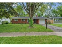 Charming single story brick home with a tree in the front yard and an attached garage at 8109 E Penway St, Indianapolis, IN 46226