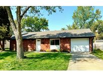 Charming single-story brick home with well-manicured lawn and attached garage at 8744 Montery Ct, Indianapolis, IN 46226