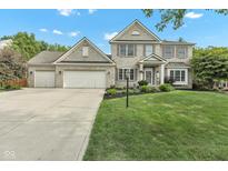 Charming two-story brick home featuring a three-car garage, landscaped yard, and manicured lawn at 8973 Carnation Dr, Noblesville, IN 46060