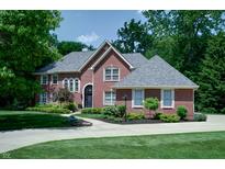 Beautiful two-story brick home featuring a well-manicured lawn, lush landscaping, and a circular driveway at 9154 Sargent Manor Ct, Indianapolis, IN 46256